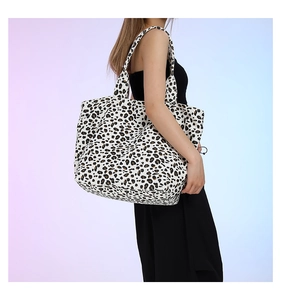 Detailed side view of the oversized leopard print canvas tote bag on female model