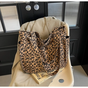 Dettaglio della borsa tote leopardata in tela con tasche laterali e manici