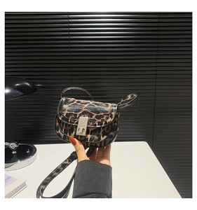 Detailed macro shot of vintage silver swivel lock on leopard print saddle crossbody bag