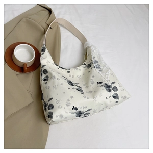 Gros plan sur le fourre-tout en toile beige avec motifs floraux noirs et dentelle