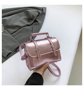 Macro detail of metallic pink wrinkled texture on mini crossbody bag with silver buckle
