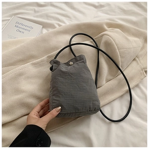 Detail of grey checkered nylon mini crossbody bag with silver button and slim strap
