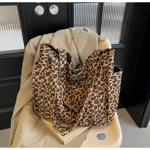 Dettaglio di una grande borsa tote in tela con stampa leopardata e doppi manici
