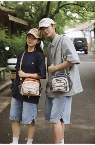 Detail of crossbody bags featuring drawstring design and contrasting color panels