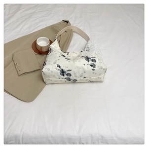 Détail du sac cabas floral crème avec nœud en dentelle blanche et anse en cuir élégant