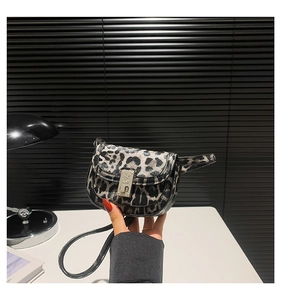 Detailed close-up of leopard print baguette bag with a silver metal clasp closure