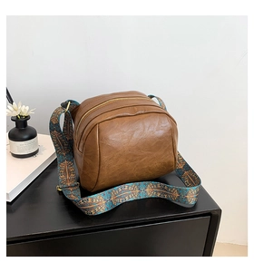Detailansicht der braunen PU-Leder-Tasche mit bohemischem geometrisch gewebtem Gurt
