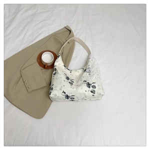 Détail du sac hobo en toile à motifs floraux avec un nœud en dentelle blanche élégant