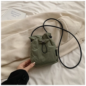 Close-up of army green nylon drawstring mini bag with subtle checkered texture