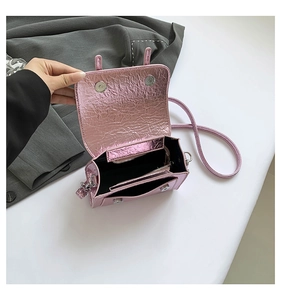 Macro view of metallic pink cracked texture bag with silver magnetic snaps and zipper pocket