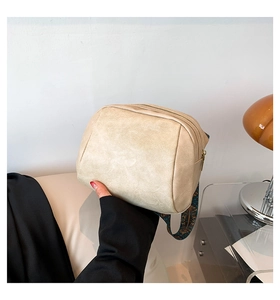 Detail der beigen strukturierten Muscheltasche mit Ethno-Gurt und Metallreißverschluss