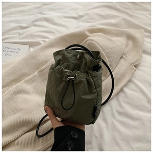 Detail of army green nylon mini drawstring bucket bag with silver metal snap button