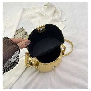 Detailed interior of a gold metallic saddle bag with soft black lining and silver magnet