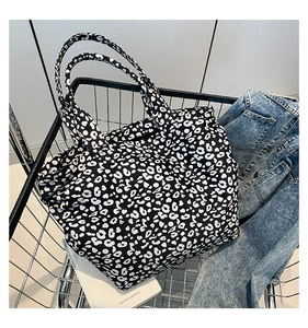 Detail shot of black and white leopard print tote bag placed in a metal shopping cart