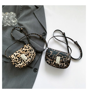 Detail showing two tones of leopard print crossbody bags with elegant metal flip locks