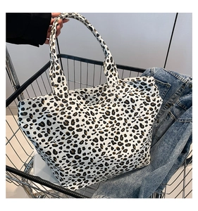 Leopard print canvas tote bag inside a metal shopping cart with a denim jacket