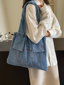 Blue denim tote bag for women featuring quilted embroidery and spacious side pockets