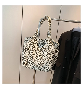 Leopard print canvas tote bag hanging next to a black blazer showing size and style