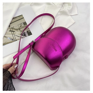 Macro view of magenta metallic crescent saddle bag featuring embossed fashion leather text