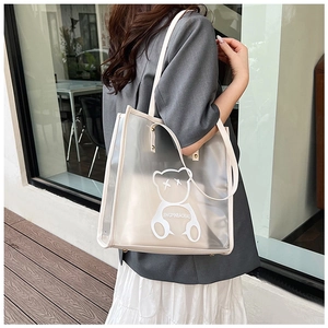 Close-up of the transparent PVC tote bag featuring a cute cartoon bear and cream piping trim