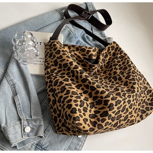Detail view of the leopard print canvas tote bag featuring adjustable dark brown straps