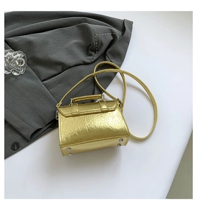 Golden metallic messenger bag with a wrinkled texture and protective metal feet at the bottom