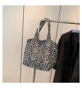 Detail of leopard print canvas tote bag hanging next to a black blazer jacket