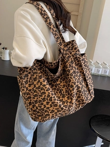 Grande borsa tote in tela con stampa leopardata e tasca laterale mostrata sulla spalla