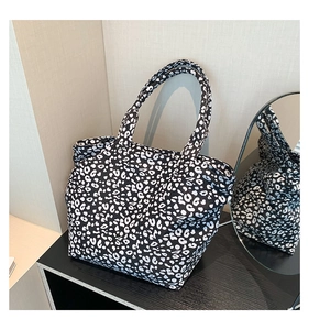 Detailed view of leopard print canvas tote bag on a textured surface with a mirror reflection