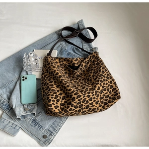 Top view of large leopard print canvas tote bag showing texture and adjustable brown strap