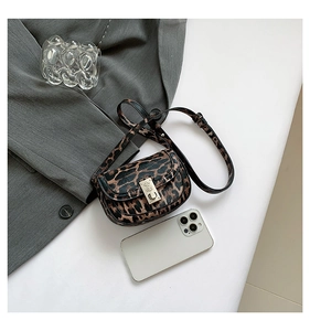 Detail view of leopard print saddle bag with silver clasp and textured leather
