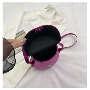 Detail view of the open magenta metallic saddle bag showing inner storage and silver magnetic snap
