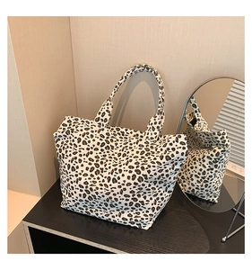 Detailed view of leopard print canvas tote bag with large capacity on wooden display