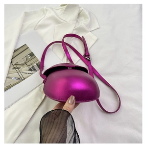 Detailed view of metallic purple saddle bag with flap closure and adjustable strap