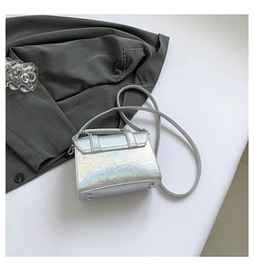 Detailed macro view of the silver holographic texture and metal studs on the messenger bag