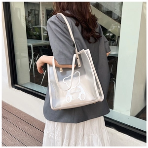 Detail of transparent PVC tote bag with cartoon bear print and reinforced rivet straps
