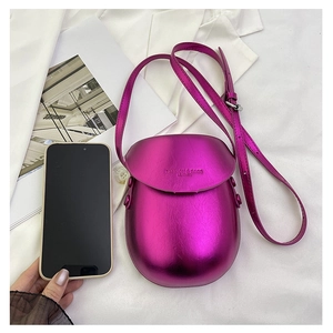 Metallic magenta mini saddle bag next to a smartphone showing compact phone size