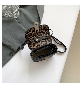 Detail view of leopard print crossbody bag with internal zip pocket and metal buckle