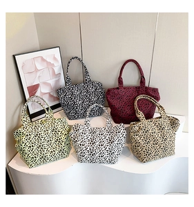 Collection of leopard print canvas tote bags in five colors on a minimalist display