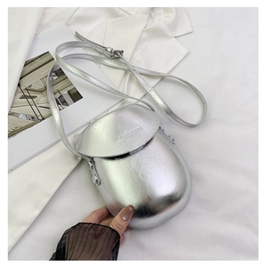 Close-up of metallic silver saddle bag with embossed fashion text and adjustable strap