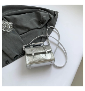 Detail of silver metallic wrinkled texture messenger bag with elegant handle and straps