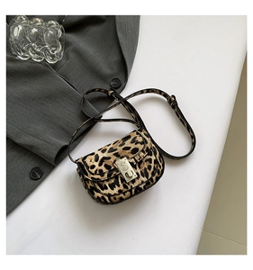 Close-up of leopard print crossbody bag with silver buckle and adjustable strap detail