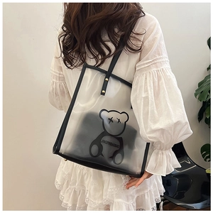 Detailed close-up of the transparent waterproof tote bag with black trim and bear motif