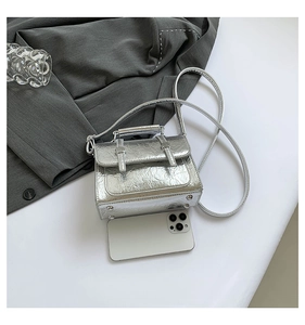 Silver wrinkled leather mini messenger bag shown with a smartphone for scale reference