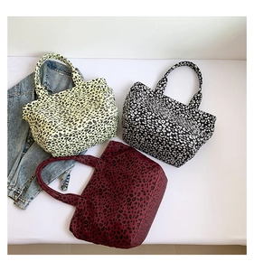 Detailed flat lay of leopard print canvas tote bags in neon yellow, black, and burgundy