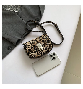Detailed view of leopard print shoulder bag with silver metal lock and textured fabric