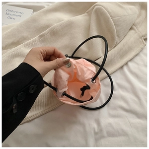 Detail of light pink mini drawstring bucket bag with silver metal snap and interior space