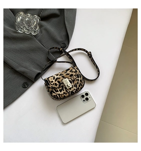 Detail of leopard print crossbody saddle bag with metal buckle and adjustable strap