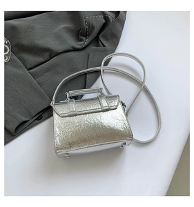 Macro shot of silver metallic crackle texture and top handle on women postman bag