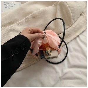 Internal view of pink mini drawstring bag showing phone and lipstick storage